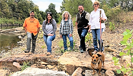 Matthew Van Eps (WCRC), Becky Roark (BWA), Barbara Fraleigh (BWA), James McCarty (BWD) and Sandi Formica (WCRC), stand on a restored section of West Fork White River in Washington County. Photo by Jacqueline Froelich / KUAF Radio