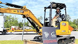 A student tests an excavator at the kickoff of the Central Arkansas Water Academy of Science & Construction